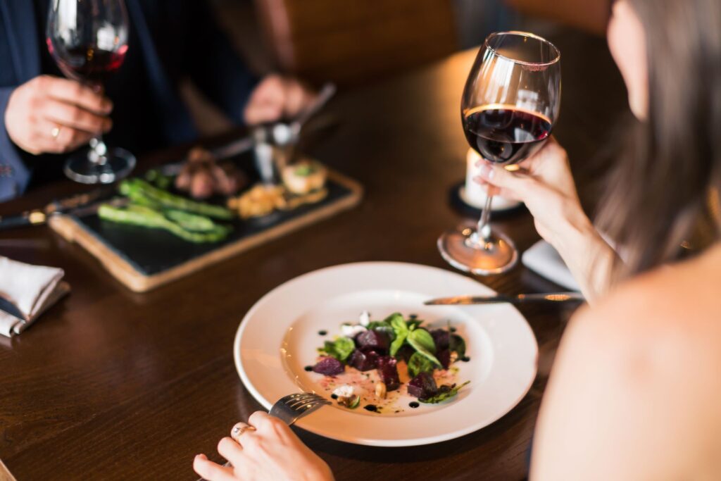 Schönes junges Paar mit einem Glas Rotwein in einem Luxusrestaurant